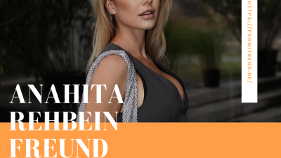 Eine Person mit langen blonden Haaren, die ein dunkles ärmelloses Oberteil und eine silberne Kettentasche trägt. Das Gesicht der Person ist verschwommen. Der Text "ANAHITA REHBEIN FREUND" ist in großen weißen Buchstaben auf einem orangefarbenen Hintergrund am unteren Rand des Bildes geschrieben. Ein vertikaler weißer Streifen auf der rechten Seite enthält die URL "HTTPS://PROMITREND.DE/".