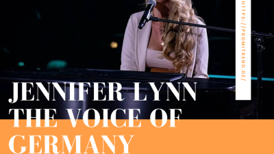 Eine Frau mit langen, lockigen Haaren sitzt an einem Klavier und singt in ein Mikrofon. Der Text auf dem Bild lautet "Jennifer Lynn The Voice of Germany". Auf der rechten Seite steht eine URL: "https://promitrend.de/".