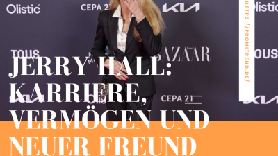 Eine Person in einem schwarzen Anzug steht vor einer Fotowand mit verschiedenen Logos. Der Text auf dem Bild lautet: "Jerry Hall: Karriere, Vermögen und neuer Freund".