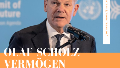 Olaf Scholz spricht bei einer Veranstaltung, Mikrofon vor ihm, Text "Olaf Scholz Vermögen" und URL "https://promitrend.de/" sichtbar.