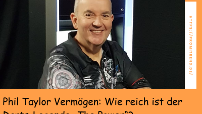 Ein unscharfes Bild eines Mannes in einem schwarzen Hemd mit Dart-Motiven. Im Hintergrund ist eine Dartscheibe zu sehen. Der Text auf dem Bild lautet: "Phil Taylor Vermögen: Wie reich ist der Darts-Legende 'The Power'?"